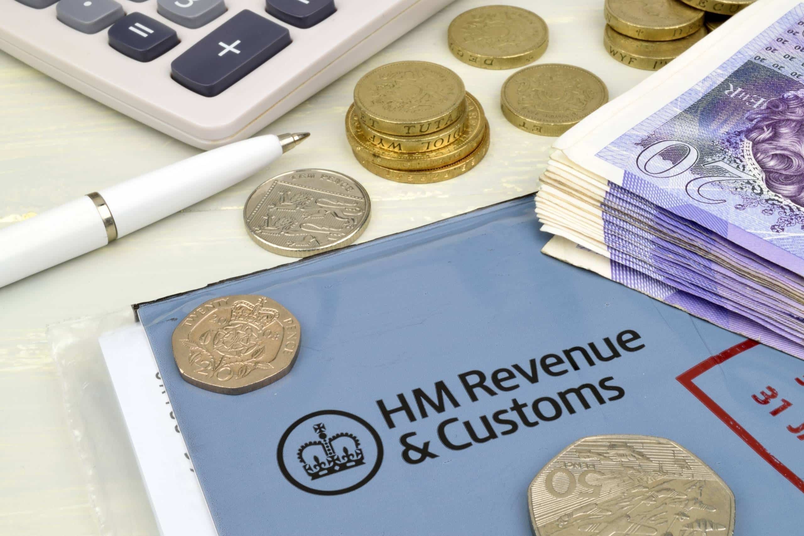 HM Revenue & Customs form with a calculator, pen, coins, and a stack of £20 notes on a desk.